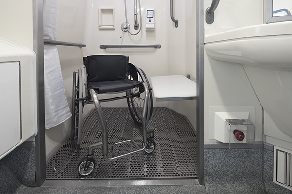 An accessible shower with a wheelchair inside.