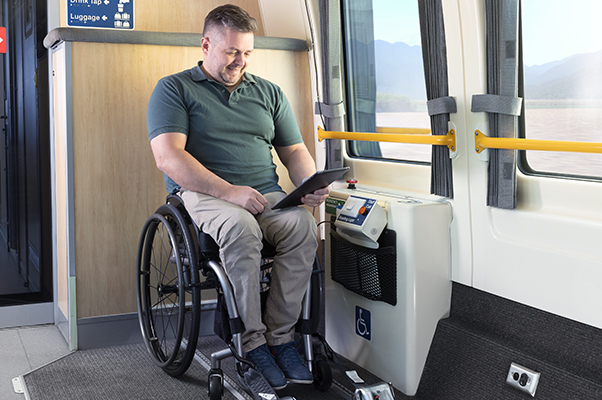 A Customer reads in a wheelchair secured with tie down straps.