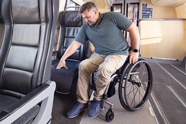 A customer transferring themselves from a wheelchair to an accessible Economy Seat.