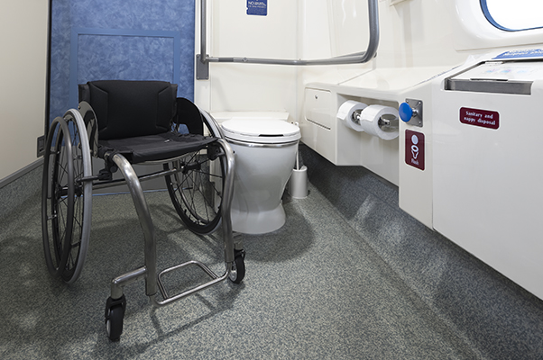 An accessible toilet with a wheelchair beside.
