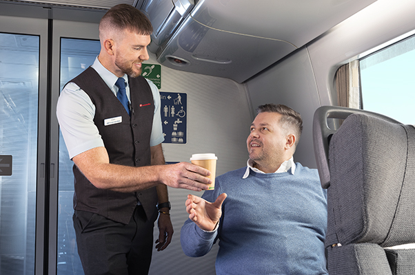 A customer is served refreshments in the Carriage A Accessible Wheelchair Space