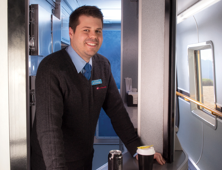 An Onboard team member smiling and ready to service customers from our Galley carriage